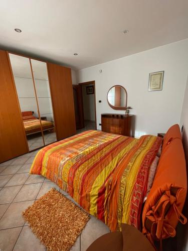 1 dormitorio con 1 cama grande con manta naranja en La casa di Chloe, en Torrevecchia Teatina