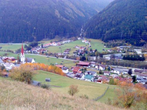 a small town on a hill with a church at Haus Mattle in Pettneu am Arlberg