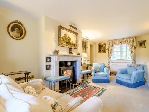 a living room with a fireplace and blue chairs at 3 Bed in Presteigne 78336 in Evenjobb