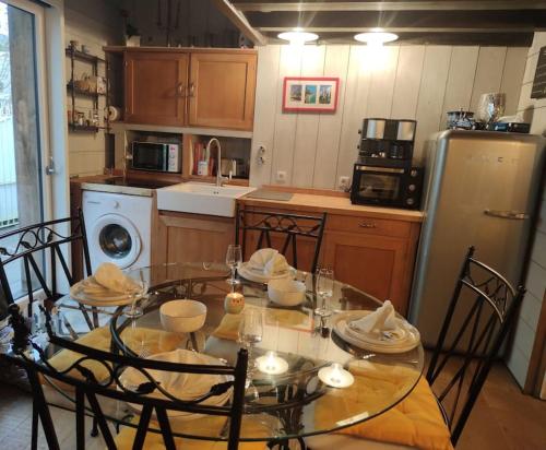 une cuisine avec une table avec des chaises et un réfrigérateur dans l'établissement Charmante cabane de pêcheur, à Cancale