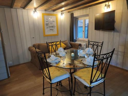 - une salle à manger avec une table, des chaises et un canapé dans l'établissement Charmante cabane de pêcheur, à Cancale