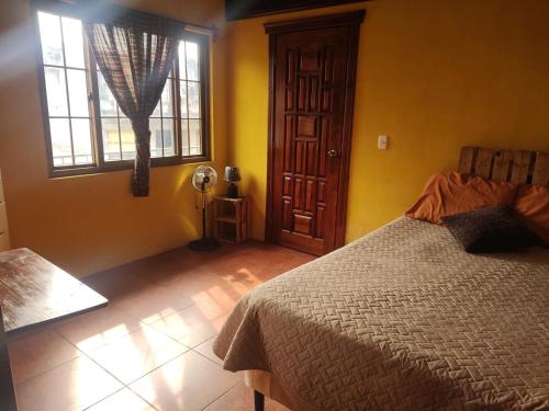 een slaapkamer met een bed en een raam bij Hosteria del Centro in Santiago Atitlán