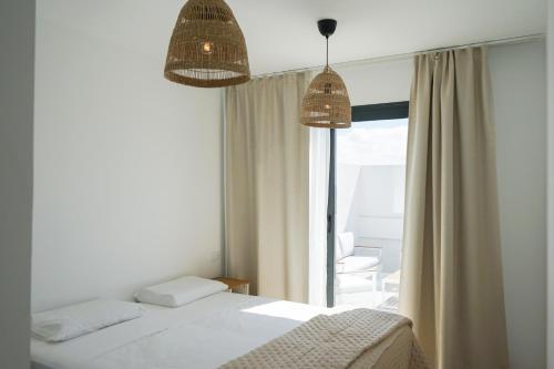 a bedroom with a bed and a large window at Casa Fuerteremote - new and modern house with office in Corralejo in La Oliva
