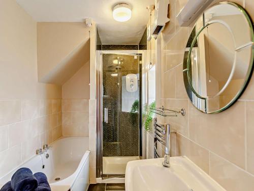 a bathroom with a tub and a sink and a mirror at 2 Bed in South Molton 88994 in Bishops Nympton