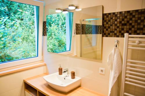 W łazience znajduje się umywalka i lustro. w obiekcie Apartment Michael - Zell am See - Kaprun w mieście Piesendorf