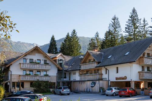 a group of buildings with cars parked in a parking lot at Art Hotel Kristal in Bohinj