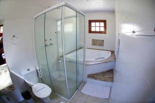 a bathroom with a shower and a toilet and a tub at Vale Encantado - Eco Park & Hotel in Biritiba-Mirim