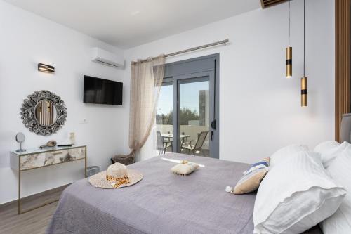 a bedroom with a bed with two hats on it at Villa Livis 2 in Kiotari