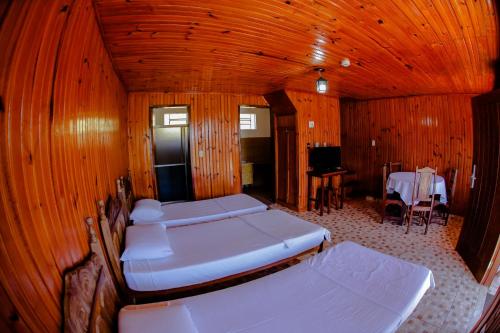 a room with three beds and a table and a television at Vale Encantado - Eco Park & Hotel in Biritiba-Mirim
