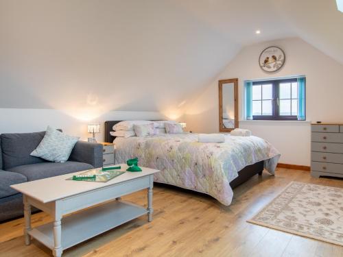 ein Schlafzimmer mit einem Bett, einem Sofa und einem Tisch in der Unterkunft 1 bed in Bath 72835 in Chew Magna