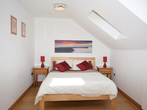 a bedroom with a bed with red pillows on it at 2 Bed in Gower 40481 in Dunvant
