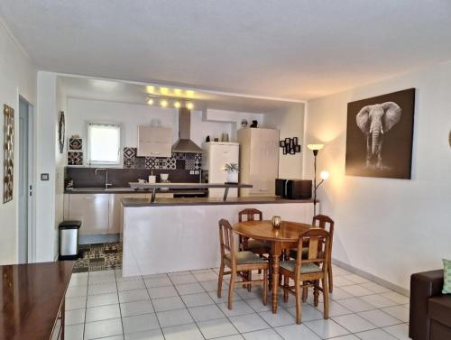 une cuisine et une salle à manger avec une table et des chaises dans l'établissement Logement agréable proche Bordeaux, à Pont-de-la-Maye
