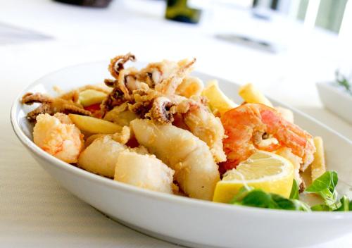 a white bowl of food with shrimp and a lemon at Puerto Bianco Private Residence Collection in Copala
