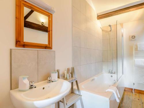 a bathroom with a sink and a tub and a mirror at 2 bed in Ramsgill 89165 in Bouthwaite