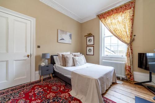 a bedroom with a bed and a tv and a window at The New Cross Premier Rooms in London