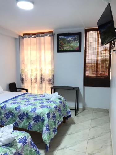a bedroom with a bed and a flat screen tv at Áncora Beach Hotel in Máncora