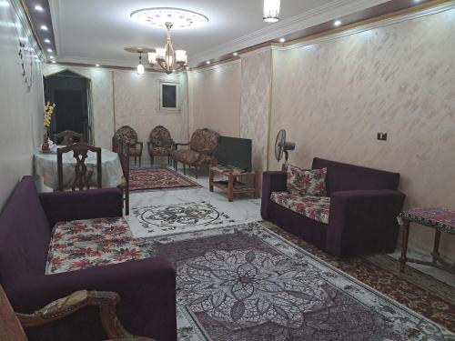 - un salon avec des canapés violets et un tapis dans l'établissement شقة مميزة جدا في قلب العاصمة قريبة من جميع الأماكن والخدمات, au Caire
