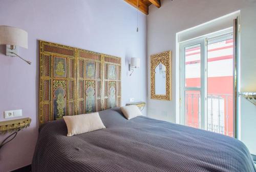 een slaapkamer met een groot bed en een groot raam bij LUXURY 3 floor house Prime Location PLAZA DE TOROS in Sevilla