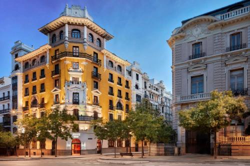 a yellow building in the middle of two buildings at Avani Alonso Martinez Madrid hotel -previously NH Alonso Martinez in Madrid