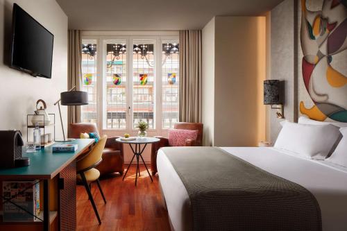 a hotel room with a bed and a desk and a window at Avani Alonso Martinez Madrid hotel -previously NH Alonso Martinez in Madrid