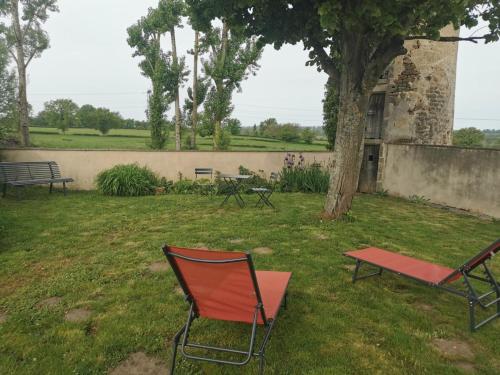 a red chair and a bench in a yard at Fermette au cœur du bocage avec jardin clos, cheminée, wifi, et proche station thermale de Bourbon - FR-1-489-490 in Saint-Aubin-le-Monial