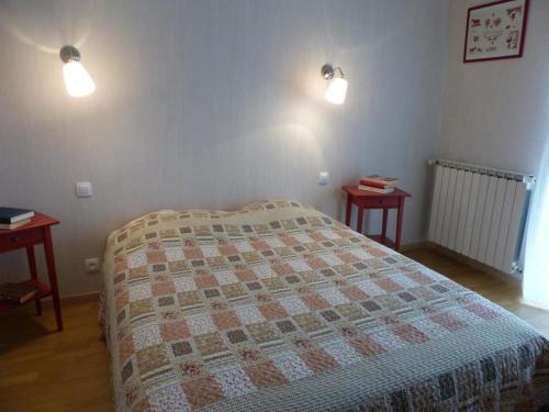 a bedroom with a bed with two tables and two lights at Fermette au cœur du bocage avec jardin clos, cheminée, wifi, et proche station thermale de Bourbon - FR-1-489-490 in Saint-Aubin-le-Monial