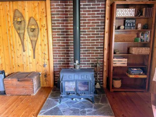 a stove in a room with a brick wall at Blue Vista Tobermory Waterfront Cottage in Tobermory