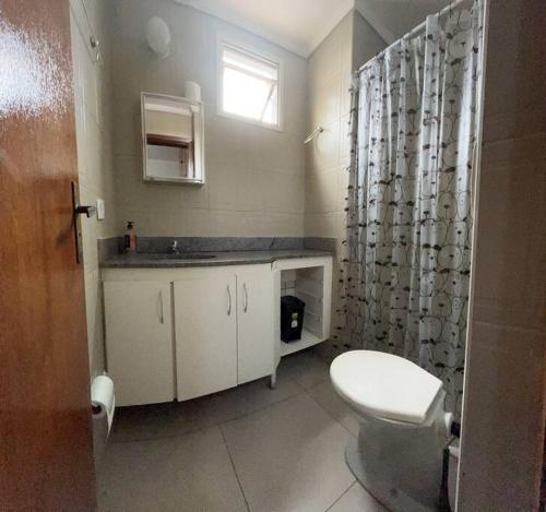 a bathroom with a toilet and a shower curtain at Made in Roça in Uberlândia