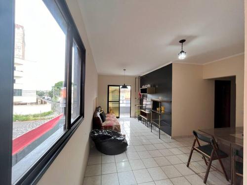 a living room with a couch and a large window at Made in Roça in Uberlândia