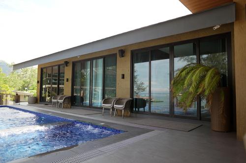 uma casa com piscina ao lado de uma casa em Emon Pulo Beach Resort 