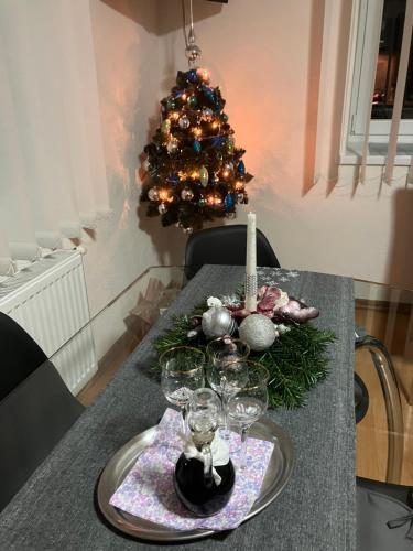 a table with a christmas tree and wine glasses at Apartmán Karin in Huty