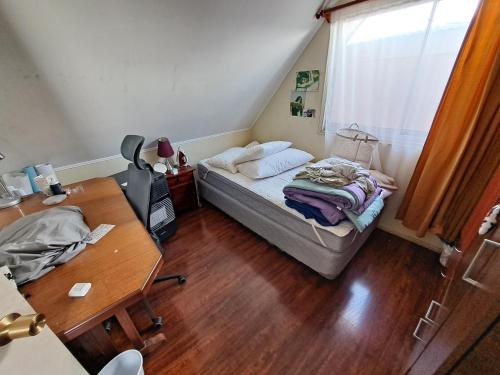 テムコにあるAlojamiento Temucoのベッドとデスクが備わる小さな客室です。
