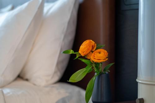 a blue vase with two orange roses in it at Nobu Hotel Atlanta in Atlanta