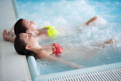 two young children playing in a hot tub at Hotel Caravelle Thalasso & Wellness in Diano Marina