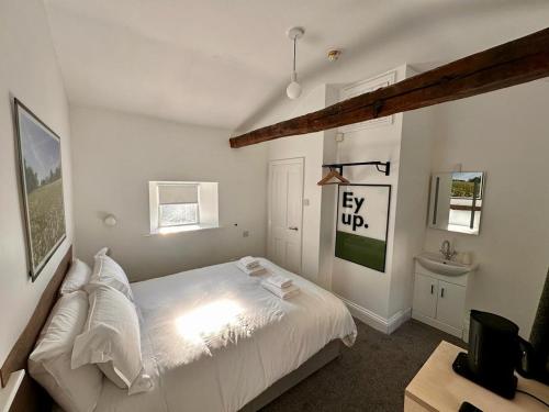 Schlafzimmer mit einem weißen Bett und einem Schreibtisch in der Unterkunft Redmire Village Pub in Redmire