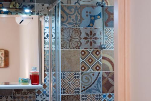 uma casa de banho com chuveiro e azulejos na parede em Sarpedon - Forest Villas Crete, near the beach em Gállos