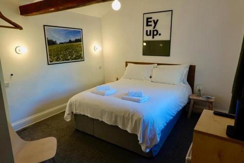 sypialnia z łóżkiem z dwoma ręcznikami w obiekcie Redmire Village Pub w mieście Redmire