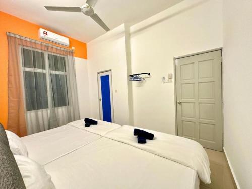 a bedroom with a white bed and an orange wall at Ipoh IGB Homestay by Comfort Home in Ipoh