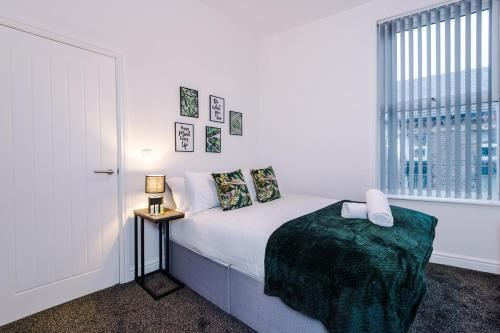 Stylish & cosy apartment near the city centre/free parking في ليفربول: غرفة نوم بيضاء بها سرير ونافذة