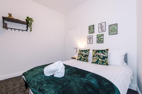 Stylish & cosy apartment near the city centre/free parking في ليفربول: غرفة نوم بسرير وبطانية خضراء