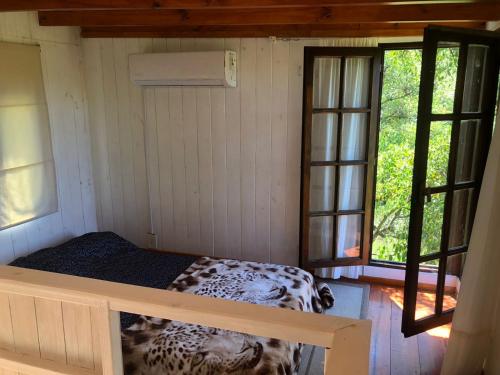 a room with a bed in a house with windows at La Tiny in Tigre