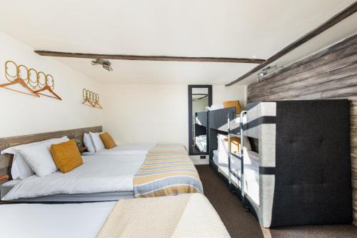 1 dormitorio con 2 camas y pared de madera en The Pine Cabins including Games Room, Camp fire & Hot tub en Bristol