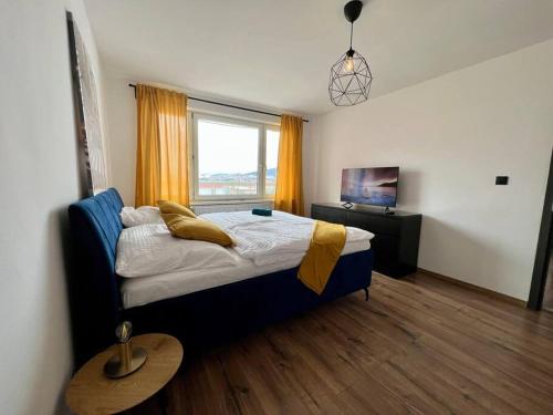 a bedroom with a bed and a window at Moderný apartmán s krásnym výhľadom v top lokalite in Žilina
