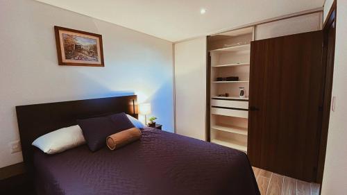 1 dormitorio con cama morada y armario en Apartamento zona 13 Aeropuerto Inara en Guatemala