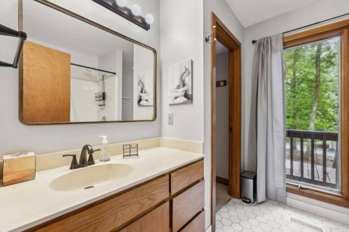 La salle de bains est pourvue d'un lavabo et d'une fenêtre. dans l'établissement Large, private home on forested lot in Chapel Hill, à Chapel Hill