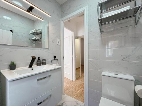 ein weißes Bad mit einem Waschbecken und einem WC in der Unterkunft Oasis Suite in Avila