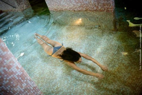 a woman is laying in a swimming pool at Hotel Relais Valle Orientina in Pitigliano