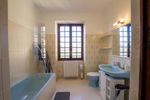 uma casa de banho com uma banheira, um lavatório e um WC. em Nouzet gites et lits em Eyzerac