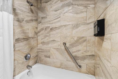 a bathroom with a shower with a bath tub at Columbia River Hotel, Ascend Hotel Collection in The Dalles in The Dalles