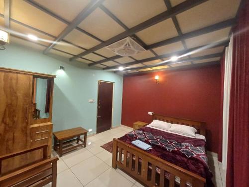 1 dormitorio con 1 cama con pared roja en Odyssey Stays Thalathmane, Coorg, en Madikeri